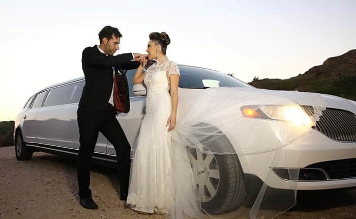זוג בצילומי חתונה ליד לימוזינה